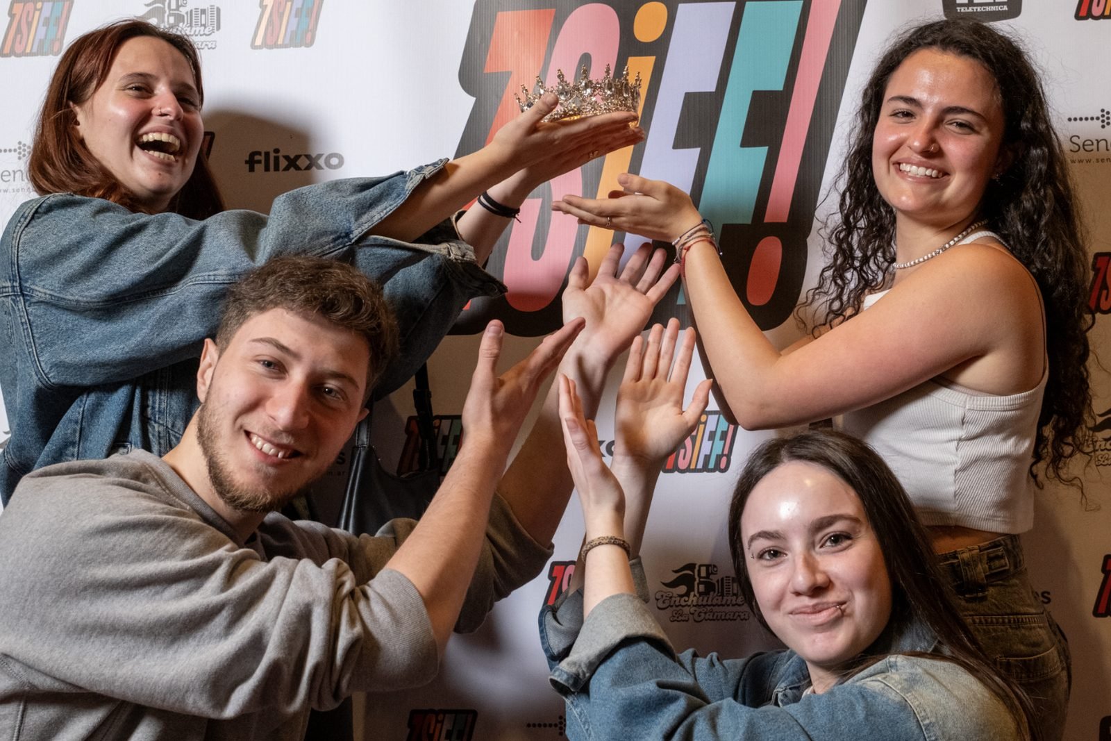 Cuatro jóvenes posan con una corona frente al logo del 7SIFF